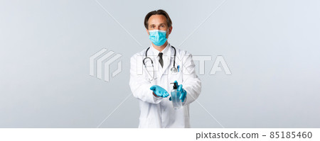 Covid-19, preventing virus, healthcare workers and vaccination concept. Doctor in medical mask and gloves explain important of hygiene, using hand sanitizer during coronavirus outbreak 85185460