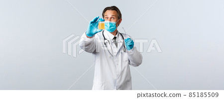 Covid-19, preventing virus, healthcare workers and vaccination concept. Excited lab scientist, doctor in clinic wear medical mask and gloves showing test sample of patient urine 85185509