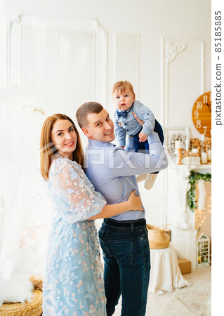 dad holds the baby son in his hands, and mom hugs. dad holds the baby son in his hands, and mom hugs. 85185885