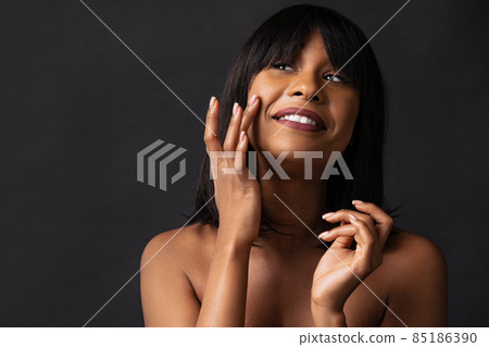 Half-length portrait of pretty dark skinned girl posing isolated over dark studio background. Natural beauty concept. 85186390