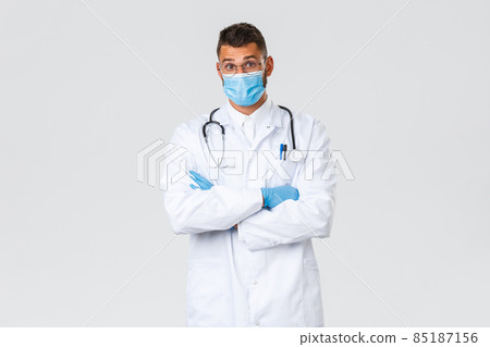Covid-19, healthcare workers, pandemic and preventing virus concept. Surprised hispanic male doctor in medical mask and scrubs raise eyebrows amazed, hear interesting case in clinic Covid-19, healthcare workers, pandemic and preventing virus concept. Surprised hispanic male doctor in medical mask and scrubs raise eyebrows amazed, hear interesting case in clinic 85187156
