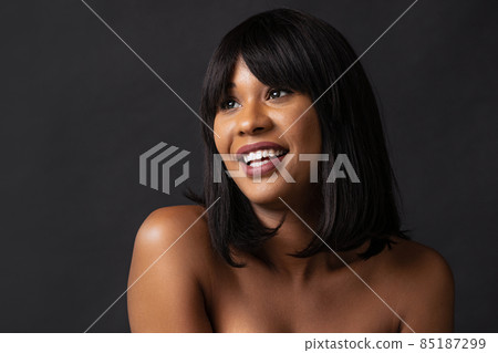 Close-up adorable dark skinned girl in underwear smiling isolated over dark studio background. Natural beauty concept. Close-up adorable dark skinned girl in underwear smiling isolated over dark studio background. Natural beauty concept. 85187299