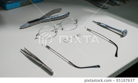 Disassembled glasses frame and tools. Optics work table. 85187637