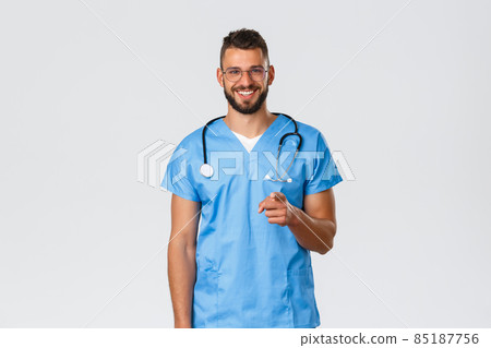 Healthcare workers, medicine, covid-19 and pandemic self-quarantine concept. Cheerful handsome, hispanic male nurse or doctor in blue scrubs, stethoscope, pointing camera showing you opportunity Healthcare workers, medicine, covid-19 and pandemic self-quarantine concept. Cheerful handsome, hispanic male nurse or doctor in blue scrubs, stethoscope, pointing camera showing you opportunity 85187756