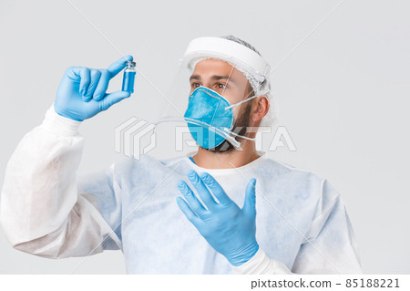 Covid-19 pandemic, virus outbreak, clinic and healthcare workers concept. Excited pationate male doctor researcher in lab clinic, wear personal protective equipment, develop coronavirus vaccine 85188221