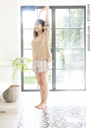 A woman welcoming a refreshing morning A woman welcoming a refreshing morning 85189044