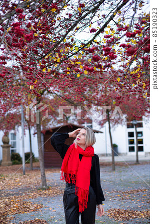 Woman in red scarf in autumn Woman in red scarf in autumn 85190323