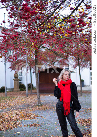 Woman in red scarf in autumn Woman in red scarf in autumn 85190325