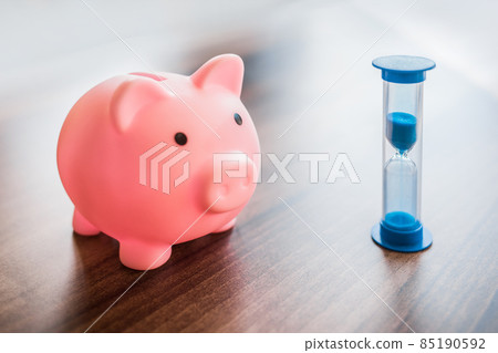 Piggy Bank Means for Money and Saving Finances Next to Hourglass Time Piggy Bank Means for Money and Saving Finances Next to Hourglass Time 85190592