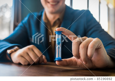 Businessman's hand holds hourglass clock timer, close-up 85190892