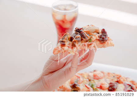 Pizza and a slice of pizza in hand Pizza and a slice of pizza in hand 85191029