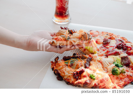 Pizza and a slice of pizza in hand Pizza and a slice of pizza in hand 85191030