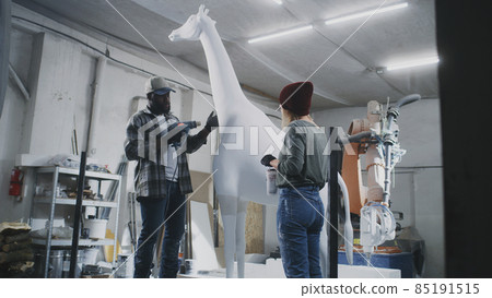 Diverse artisans making giraffe statue together Diverse artisans making giraffe statue together 85191515