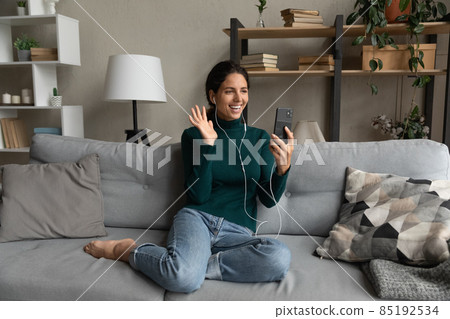 Smiling Latin woman talk on video call on smartphone 85192534