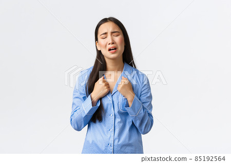 Miserable and sad asian girl in blue pajamas crying and complaining, feeling distressed, standing upset over white background, calling for help or grieving, posing over white background Miserable and sad asian girl in blue pajamas crying and complaining, feeling distressed, standing upset over white background, calling for help or grieving, posing over white background 85192564