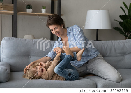 Excited happy mom cuddling, tickling cheerful cute preschool son kid Excited happy mom cuddling, tickling cheerful cute preschool son kid 85192569