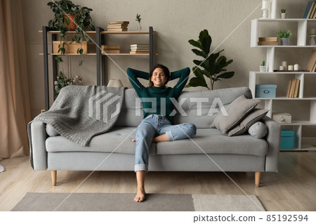 Young lady sit on sofa at home in relaxed pose Young lady sit on sofa at home in relaxed pose 85192594