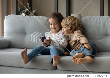 Sweet little gen Z kids using online app on smartphone 85192751