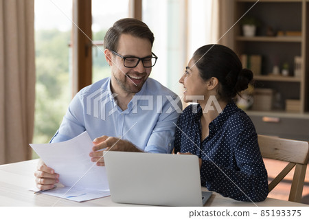 Happy multiethnic professional coworkers talking and laughing at workplace Happy multiethnic professional coworkers talking and laughing at workplace 85193375