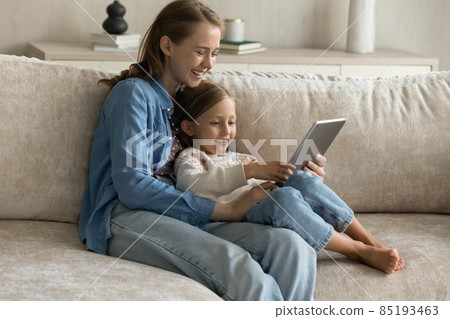 Smiling bonding multigenerational female family using touchpad gadget. Smiling bonding multigenerational female family using touchpad gadget. 85193463