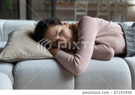 Close up unhappy woman lying on couch at home alone 85193498