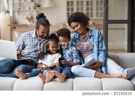 African family with kids sit on couch with diverse devices African family with kids sit on couch with diverse devices 85193810
