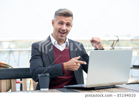 Happy professional employee make winning gesture pointing finger at laptop outside, won 85194010
