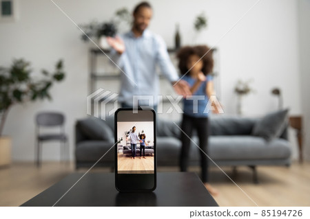 Happy African American family recording video on cellphone web camera. Happy African American family recording video on cellphone web camera. 85194726