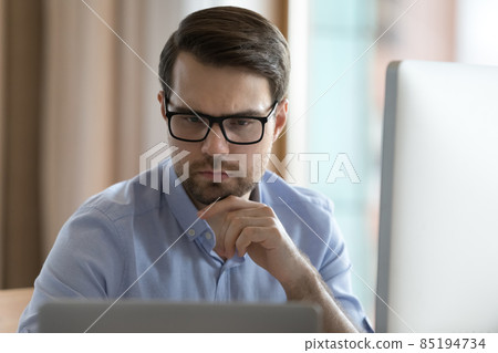 Focused business professional man in glasses working on project Focused business professional man in glasses working on project 85194734