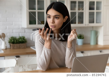 Young Asian woman talking on speakerphone solve business from home 85194741