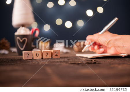 2022 sign on wooden cubes with christmas holiday decorations in background 2022 sign on wooden cubes with christmas holiday decorations in background 85194785
