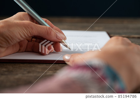 Female hand signing a document, application form 85194786
