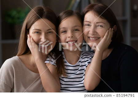 Affectionate tween girl caress cheeks of retired grandmother young mother 85194791