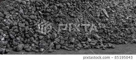 Big heap of dark black lump coal on floor bulk. Charcoal sorage at warehouse stock reserve. activated anthracite pile. Power and heat generation. Industrial and mining industry background Big heap of dark black lump coal on floor bulk. Charcoal sorage at warehouse stock reserve. activated anthracite pile. Power and heat generation. Industrial and mining industry background 85195043