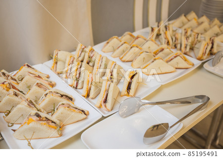 Club sandwiches delivered for catering on venue.Delicious fresh snacks for big company. Club sandwiches delivered for catering on venue.Delicious fresh snacks for big company. 85195491