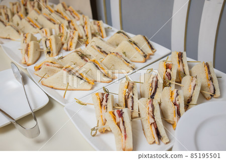 Club sandwiches delivered for catering on venue.Delicious fresh snacks for big company. Club sandwiches delivered for catering on venue.Delicious fresh snacks for big company. 85195501