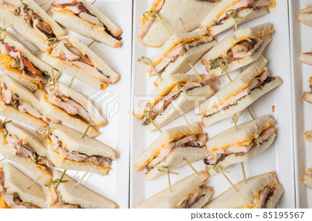Club sandwiches delivered for catering on venue.Delicious fresh snacks for big company. Club sandwiches delivered for catering on venue.Delicious fresh snacks for big company. 85195567
