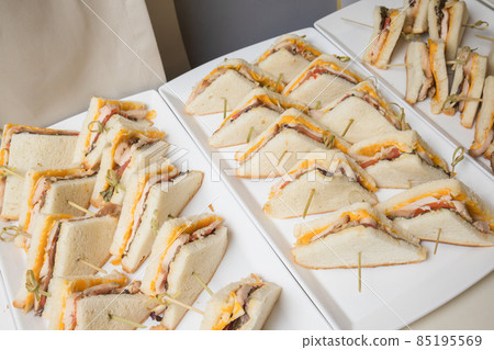 Club sandwiches delivered for catering on venue.Delicious fresh snacks for big company. Club sandwiches delivered for catering on venue.Delicious fresh snacks for big company. 85195569