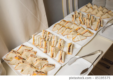 Club sandwiches delivered for catering on venue.Delicious fresh snacks for big company. Club sandwiches delivered for catering on venue.Delicious fresh snacks for big company. 85195575