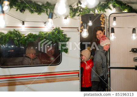 Happy large family celebrates christmas in nature. Parents with three sons travels in a mobile home. Happy large family celebrates christmas in nature. Parents with three sons travels in a mobile home. 85196313