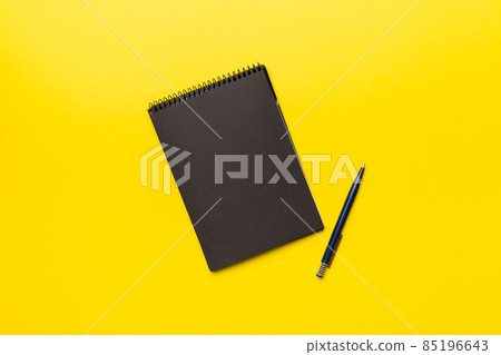 school notebook on a colored background, spiral black notepad on a table Top view school notebook on a colored background, spiral black notepad on a table Top view 85196643