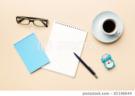 Modern office desk table with notebook and other supplies with cup of coffee. Blank notebook page for you design. Top view, flat lay 85196644