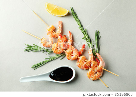 Tasty grilled shrimps skewers on gray background Tasty grilled shrimps skewers on gray background 85196803