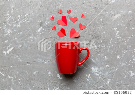 red cup on colored background, splashes of red little hearts, top view with copy space red cup on colored background, splashes of red little hearts, top view with copy space 85196952