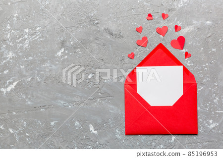 Red paper envelope with empty white card and heart on colored background. top view valentines day concept Red paper envelope with empty white card and heart on colored background. top view valentines day concept 85196953