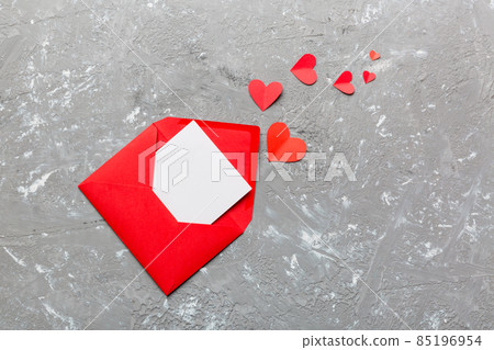 Red paper envelope with empty white card and heart on colored background. top view valentines day concept Red paper envelope with empty white card and heart on colored background. top view valentines day concept 85196954