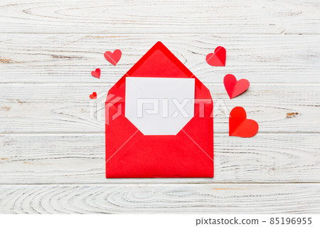 Red paper envelope with empty white card and heart on colored background. top view valentines day concept Red paper envelope with empty white card and heart on colored background. top view valentines day concept 85196955
