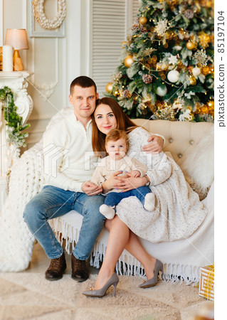 happy family on the couch by Christmas tree.  85197104