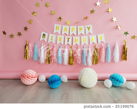 The pink decor of the birthday for girl with paper balloons, garlands, pompoms. The pink decor of the birthday for girl with paper balloons, garlands, pompoms. 85199076