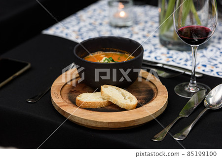 Seafood spicy soup with potatoes, shrimps, herbs and fish from a picad closeup in a pan served with toast. horizontal 85199100